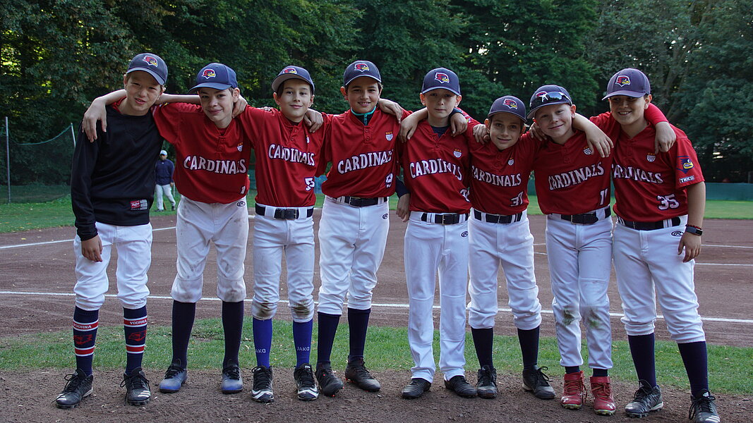Gruppenfoto von Baseballteam auf einem Baseballplatz.