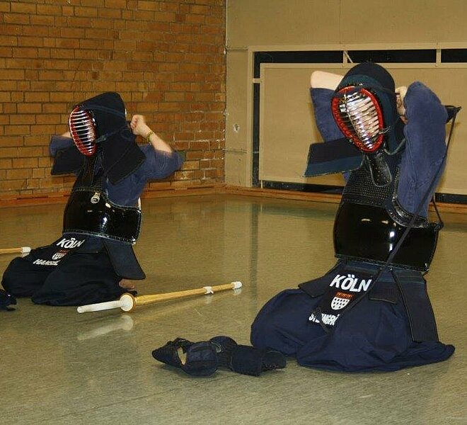 Kendo-Kämpfer in voller Montur in einer Trainingshalle.